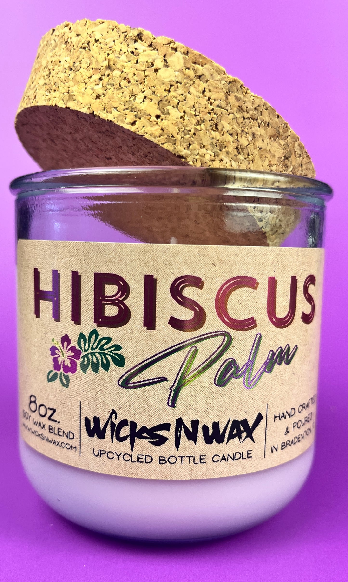 Recycled glass candle with cork lid tilted and Hibiscus label on glass jar