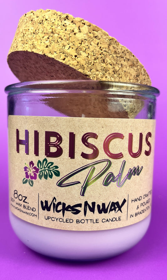 Recycled glass candle with cork lid tilted and Hibiscus label on glass jar