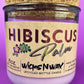 Recycled glass candle centered in purple glass jar with cork lid and Hibiscus label