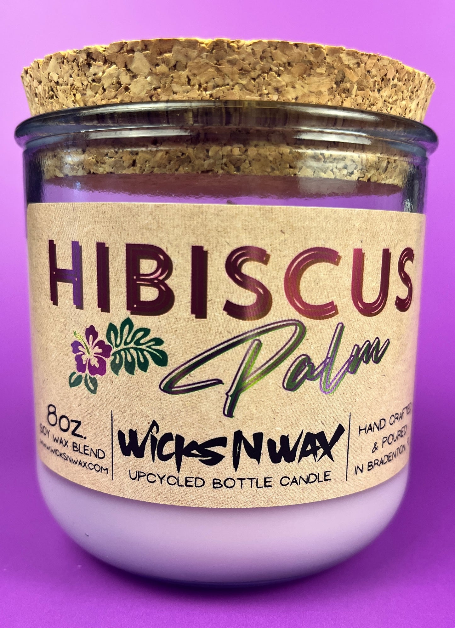 Recycled glass candle centered in purple glass jar with cork lid and Hibiscus label