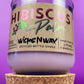 Recycled glass candle in purple jar with Hibiscus label, on cork coaster