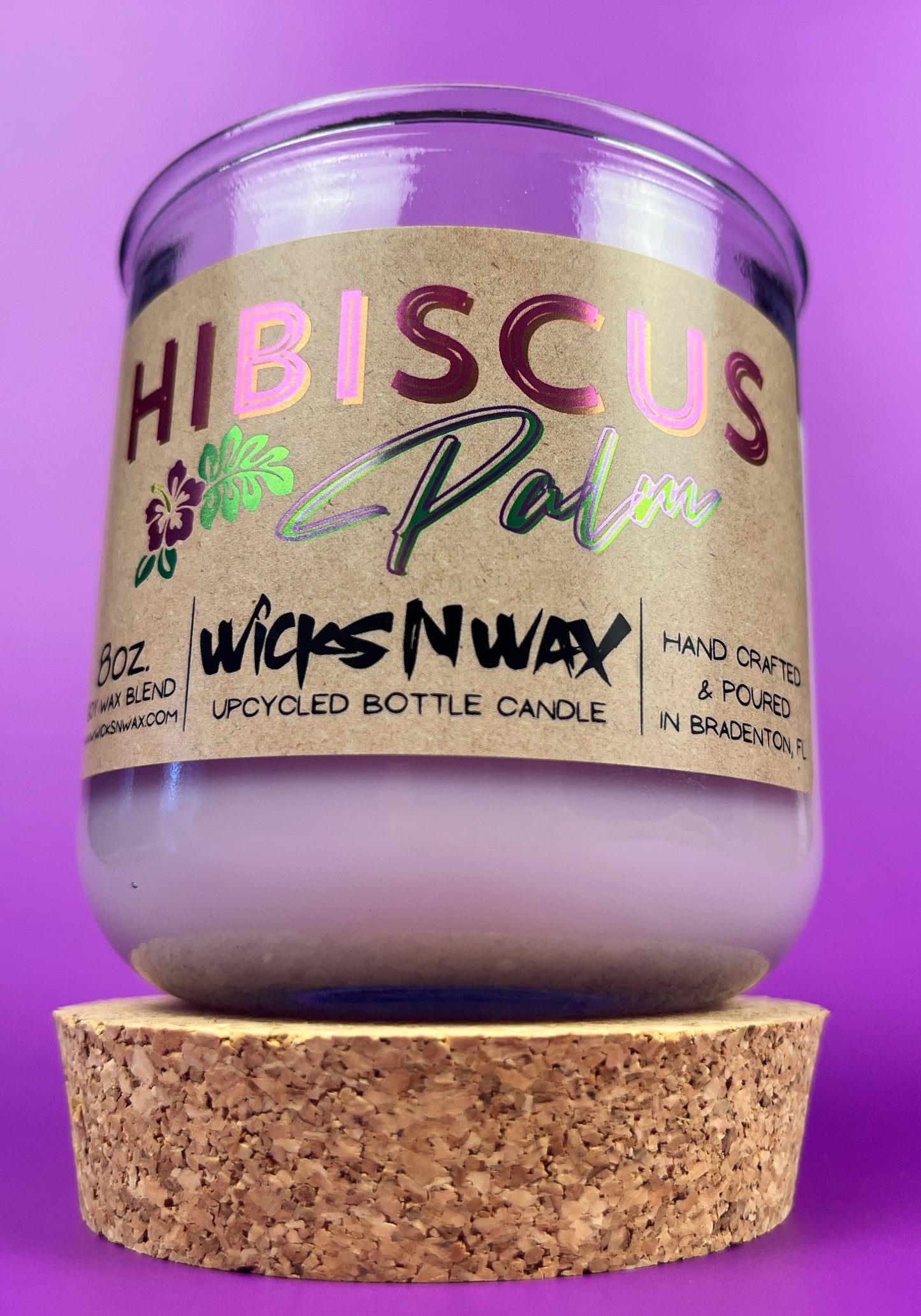 Recycled glass candle in purple jar with Hibiscus label, on cork coaster