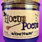 Purple glass candle with cork lid and kraft label reading Hocus Pocus