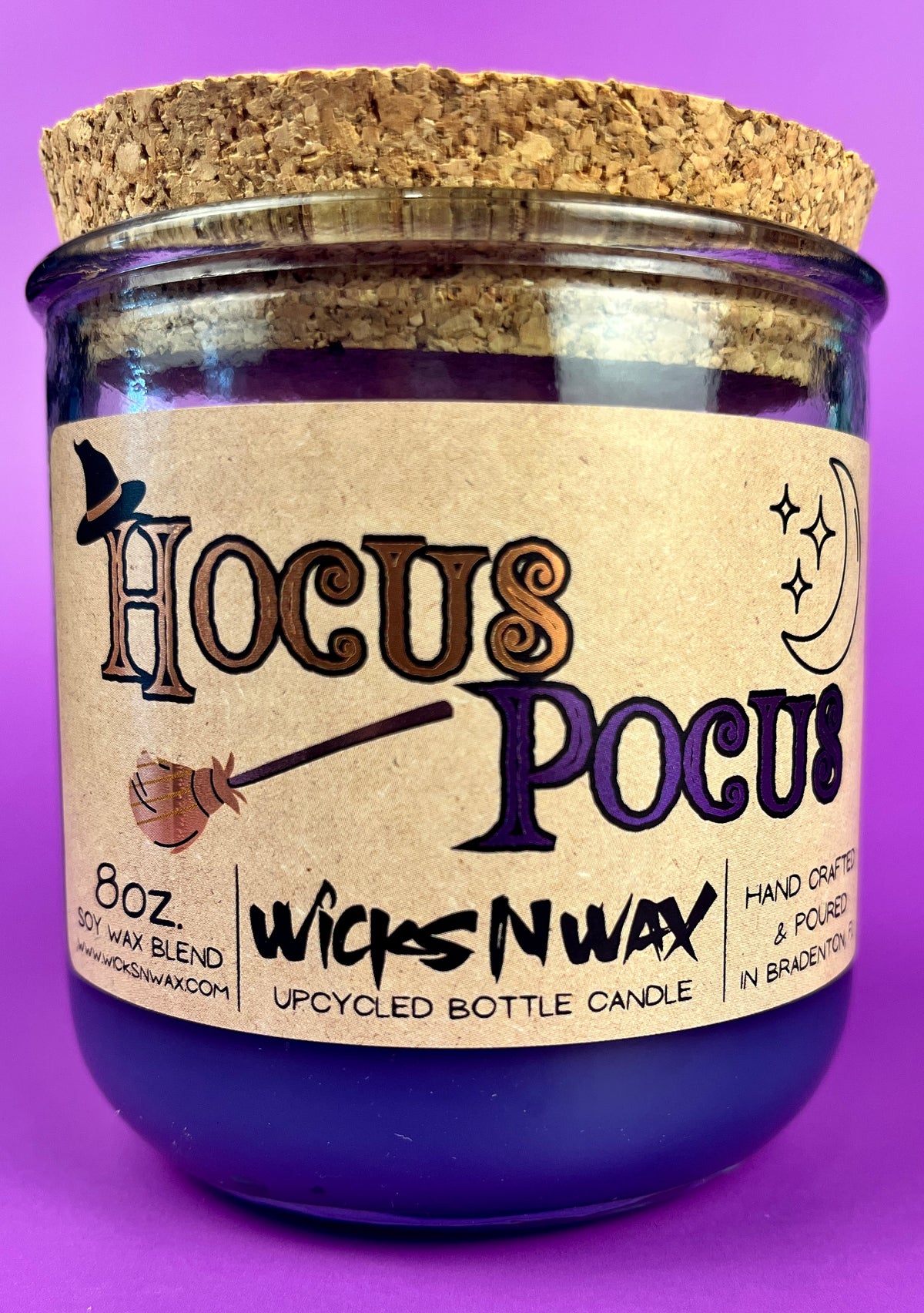 Purple glass candle with cork lid and kraft label reading Hocus Pocus