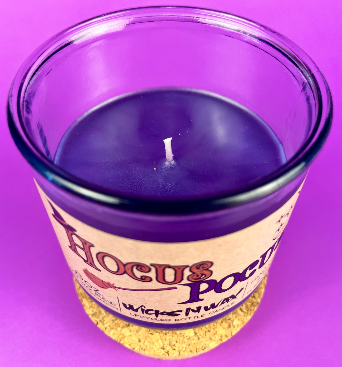 Candle jar with dark purple wax and a centered wick