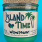 Recycled glass bottle candle with green wax and cork lid, teal glass jar with label on front.