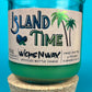 Recycled glass bottle candle with green wax and cork base, teal glass jar with label front.