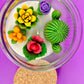 Large cactus art candle in glass jar with multi-color flower wax toppers and white wick