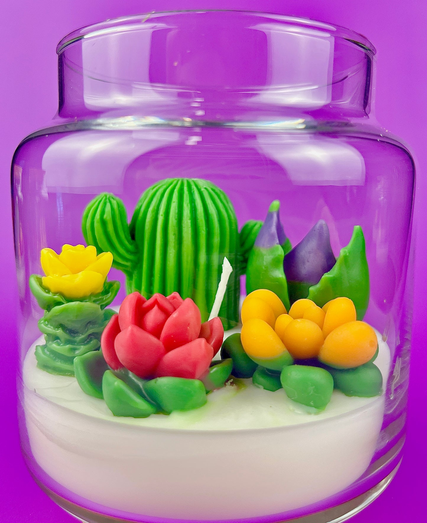 Cactus art candle in clear jar: white wax with green cactus and yellow and red floral accents
