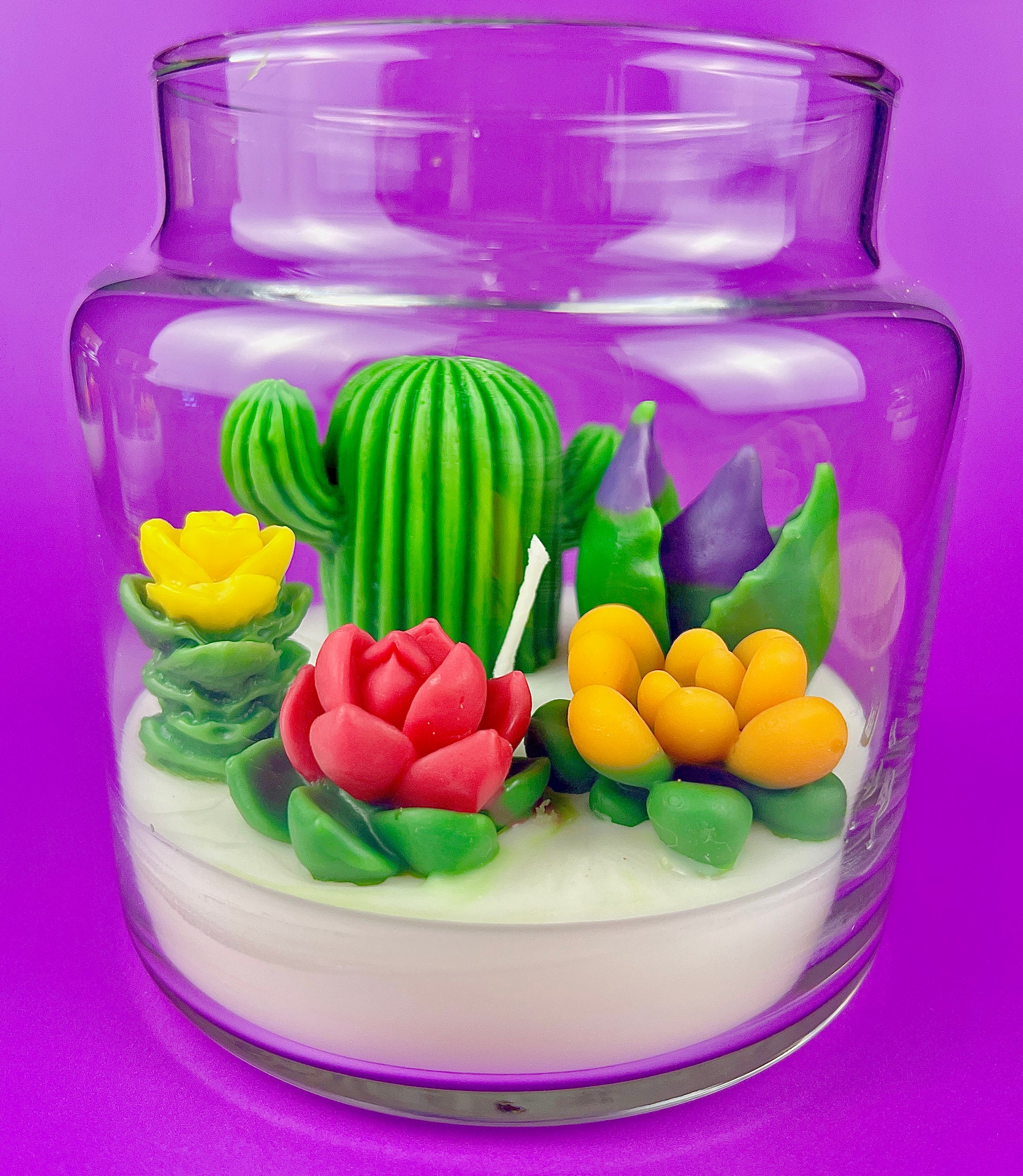 Cactus art candle in clear jar with cork lid; white wax with green cactus and red flowers