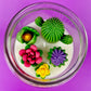 Cactus art candle lid-top view: white wax with green cactus and pink and purple blooms