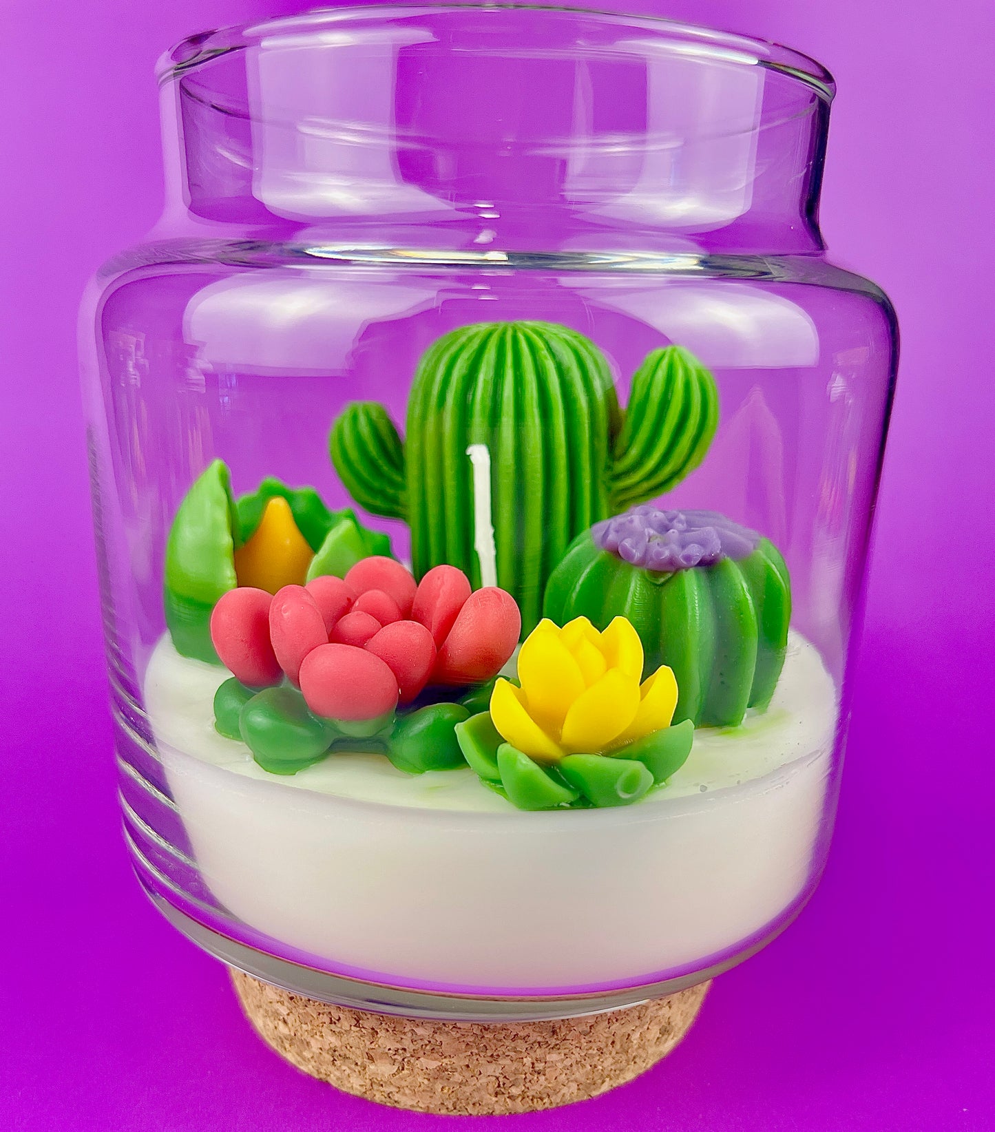 Cactus art candle in clear jar with cork base; white wax with green cactus and red petals