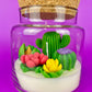Cactus art candle with clear jar and cork lid; white wax with green cactus and pink petals