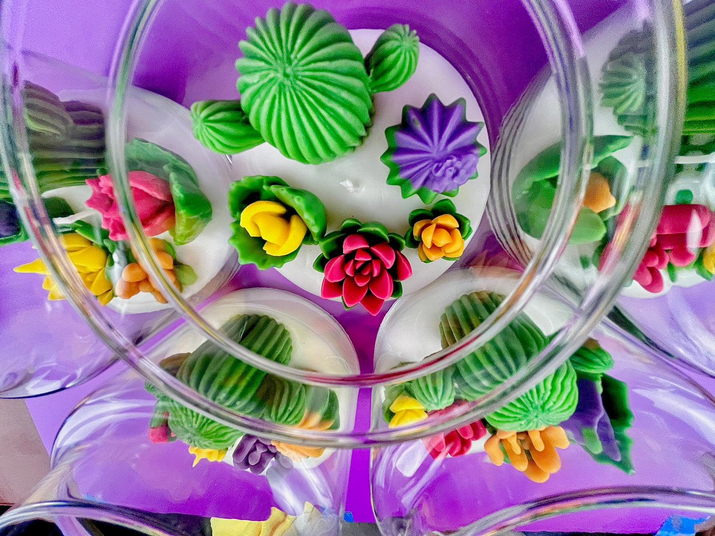 Large cactus art candle with cactus and flower wax pieces, seen through clear glass
