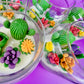Large cactus art candles in glass jars with green cactus wax and colorful flower toppers