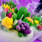 Large cactus art candle with colorful cactus and flower wax toppers on a white base
