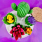 Large cactus art candle close-up with green cactus wax and colorful flower waxes in white wax