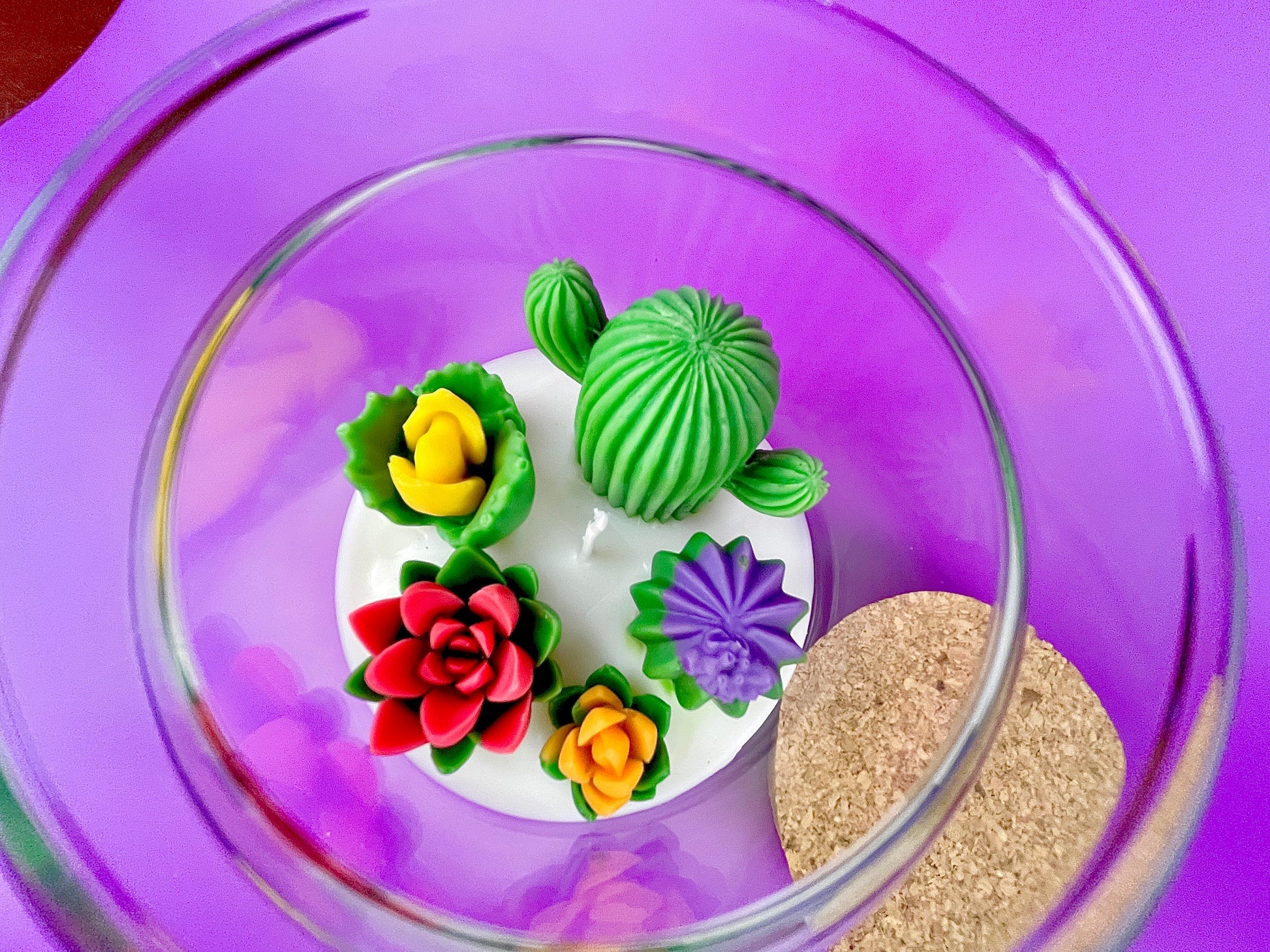 Large cactus art candle in glass jar with green cactus and red, yellow, and purple flower waxes