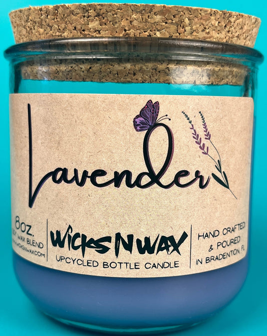 Lavender recycled glass candle in blue jar with kraft label and lavender sprig.