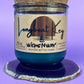 Recycled glass candle in blue wax with cork lid on top, on coaster, label centered