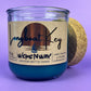 Recycled glass candle in blue wax, cork lid beside jar, front label visible