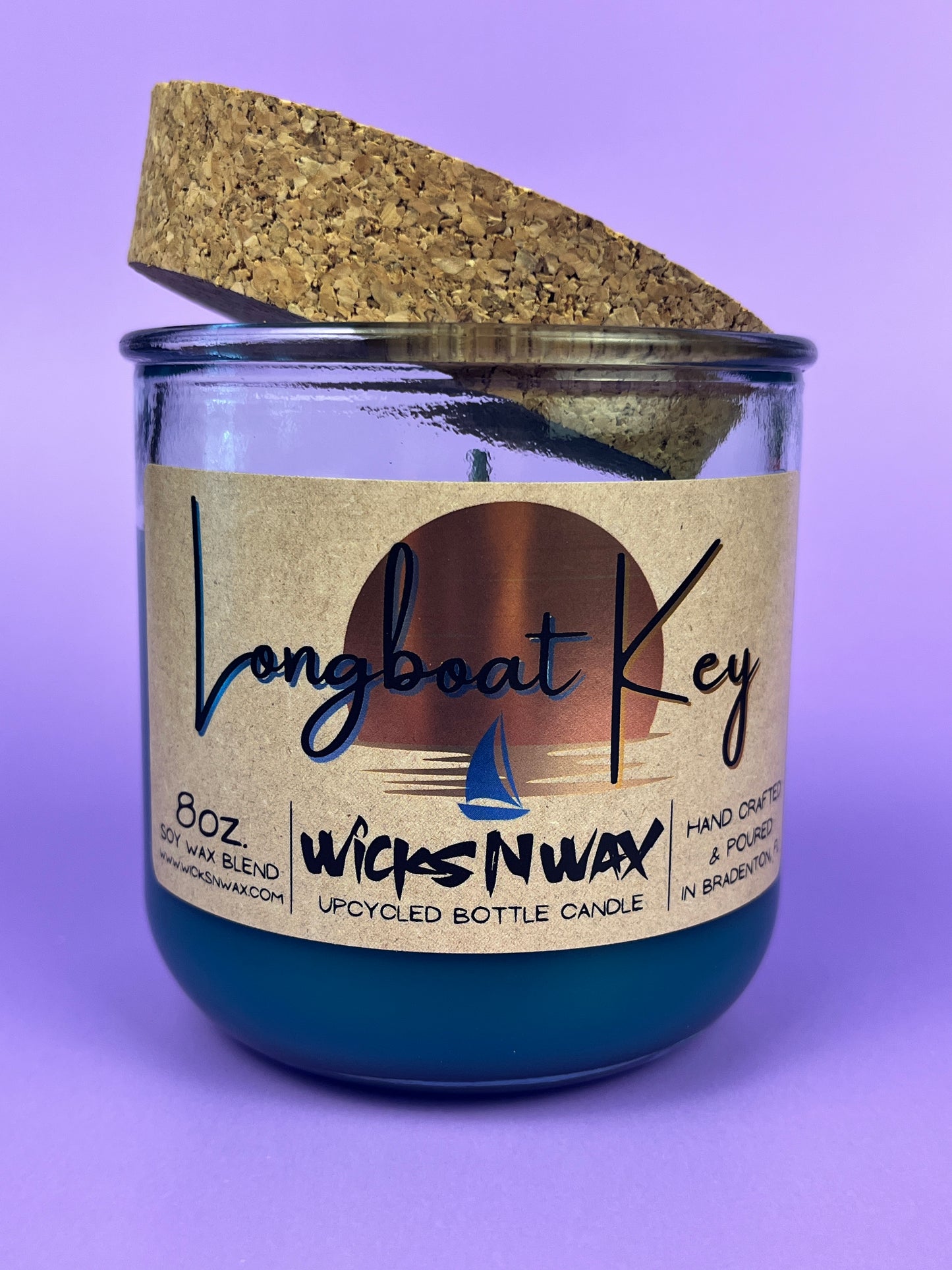 Recycled glass candle in blue wax, cork lid on top, jar front label visible