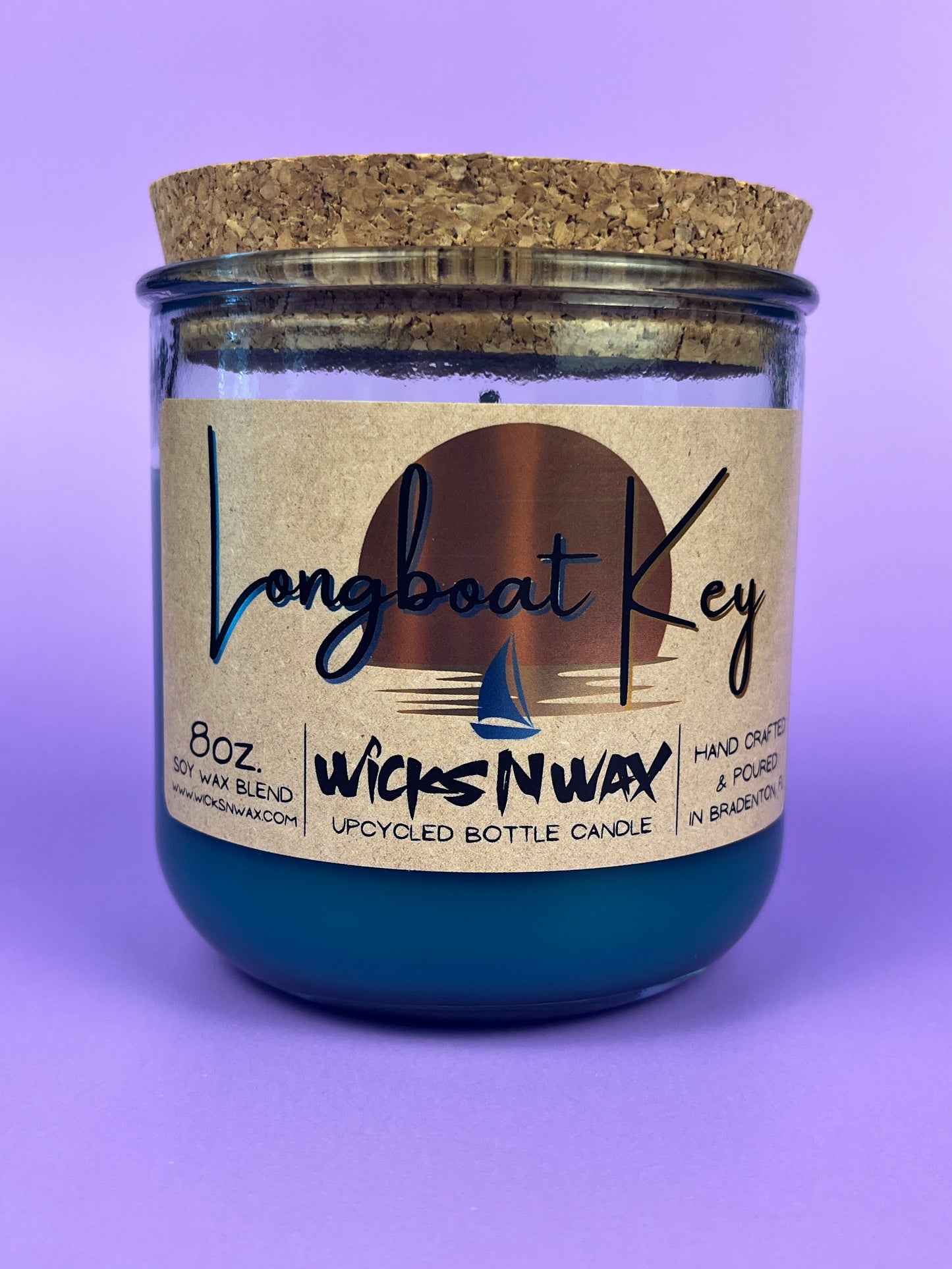 Recycled glass candle in blue wax, cork lid on top, front label and wick icon