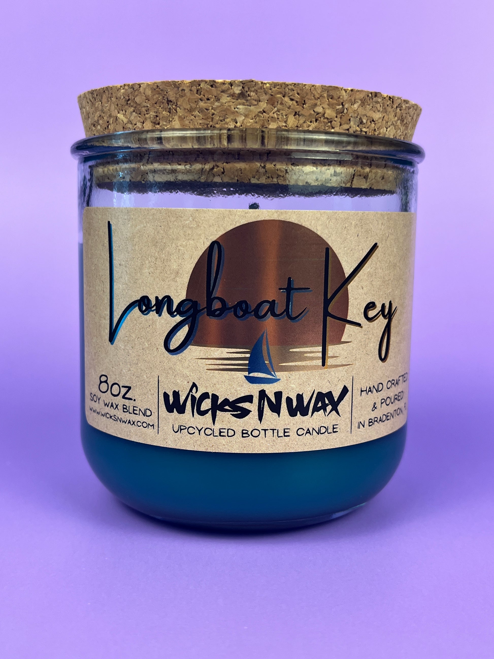 Recycled glass candle in blue wax, cork lid on top, front label and wick icon