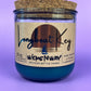 Recycled glass candle in teal jar with cork lid and printed front label