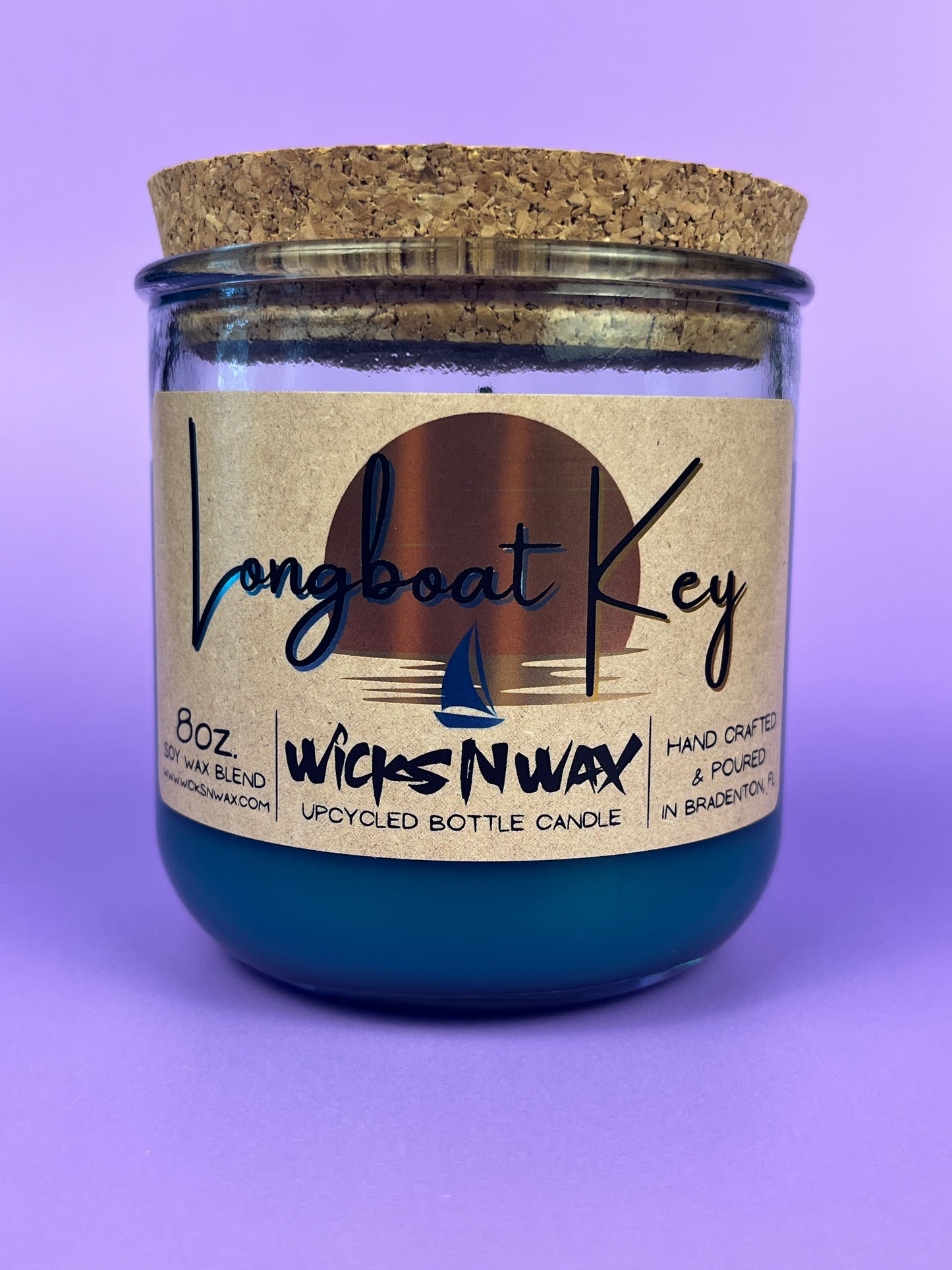 Recycled glass candle in teal jar with cork lid and printed front label