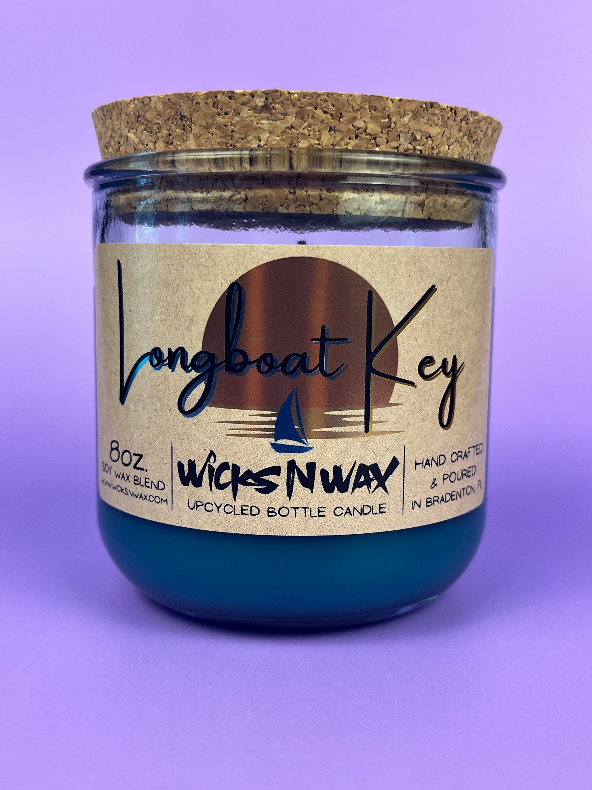 Recycled glass candle in teal jar with cork lid and printed front label