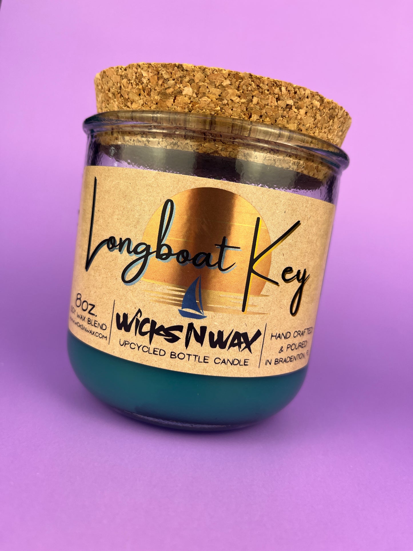 Recycled glass candle in blue wax, cork lid on top, round jar with front label