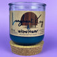 Recycled glass candle in blue wax, cork base ring under jar, front label visible
