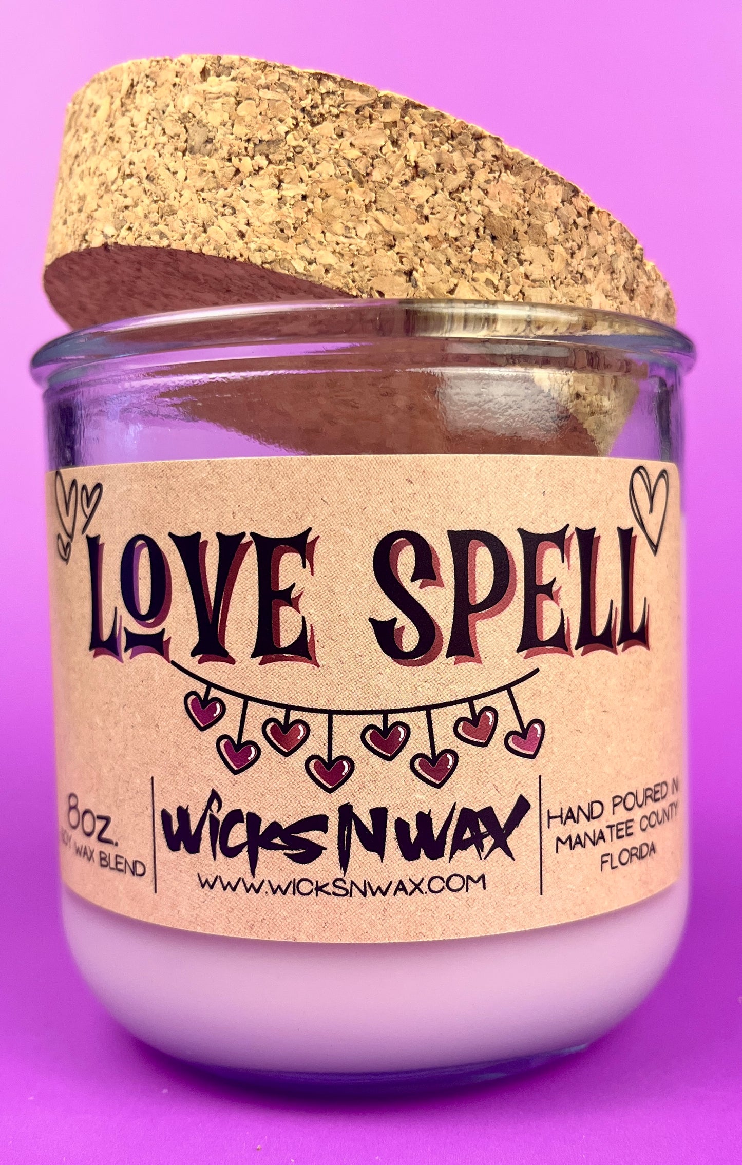 Recycled glass candle, purple jar with cork lid; beige label reading 'LOVE SPELL'