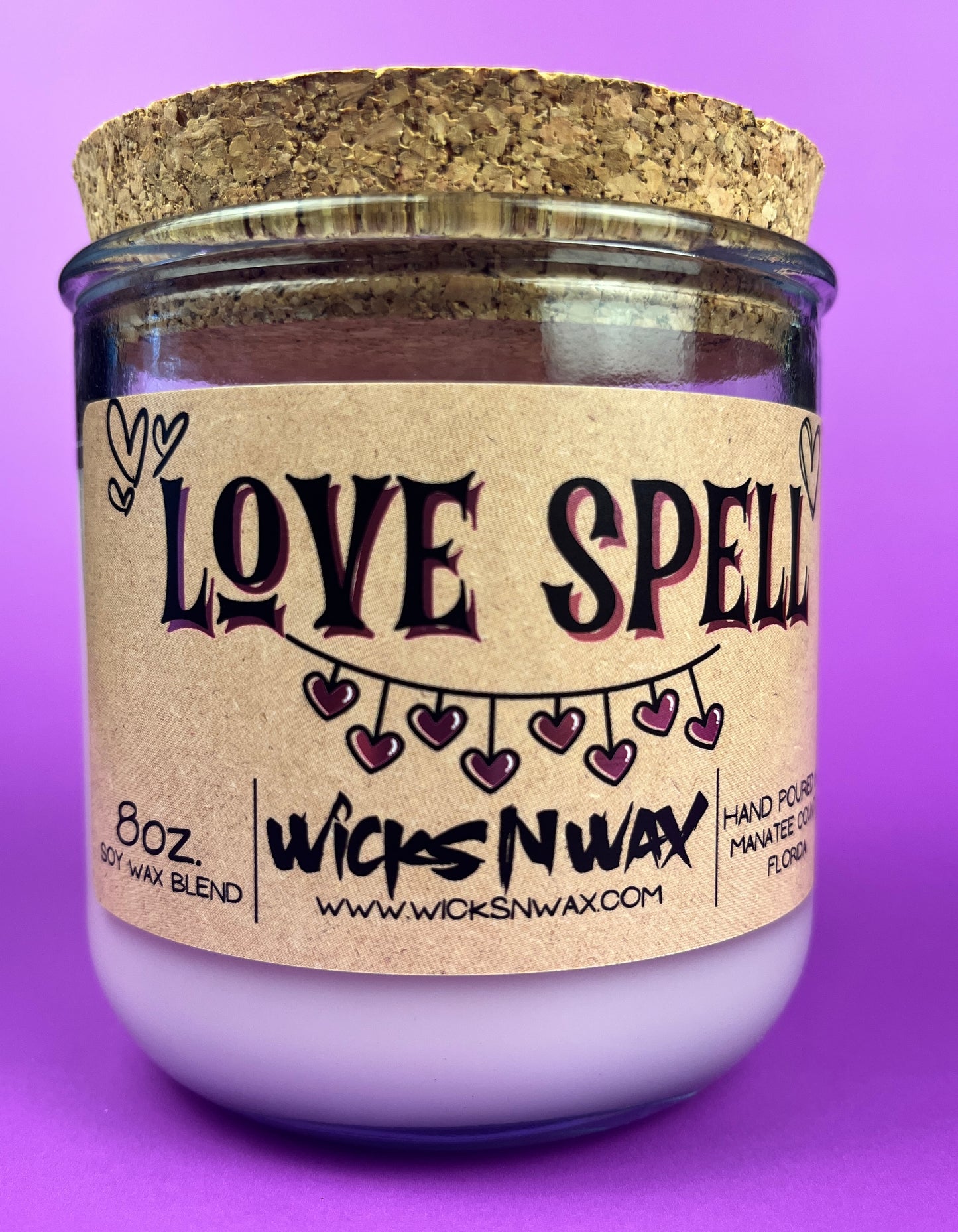 Recycled glass candle, purple jar with cork lid; beige 'LOVE SPELL' label on front