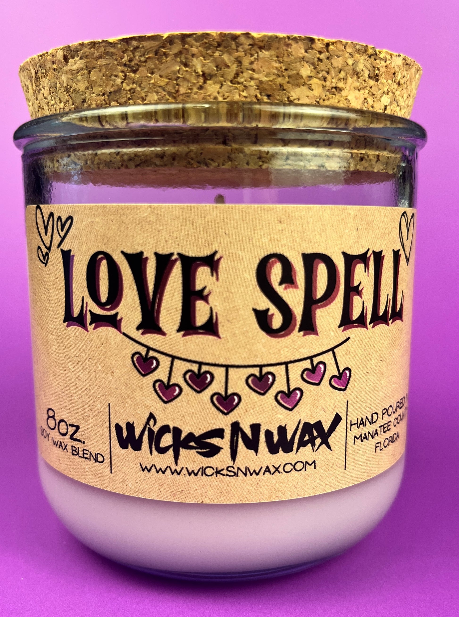 Recycled glass candle in purple glass with cork lid; beige label says 'LOVE SPELL'