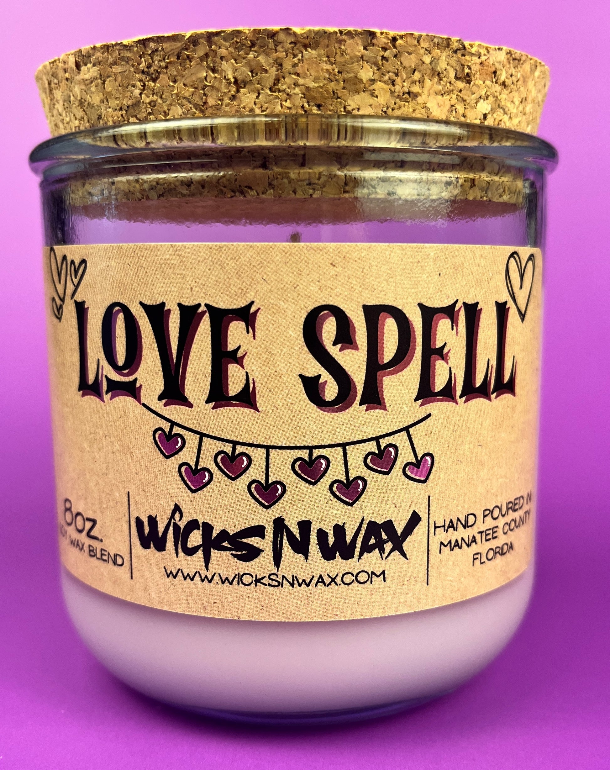 Recycled glass candle in purple glass with cork lid; beige label says 'LOVE SPELL'