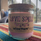 Recycled glass candle, purple jar with cork lid; 'LOVE SPELL' label on striped fabric