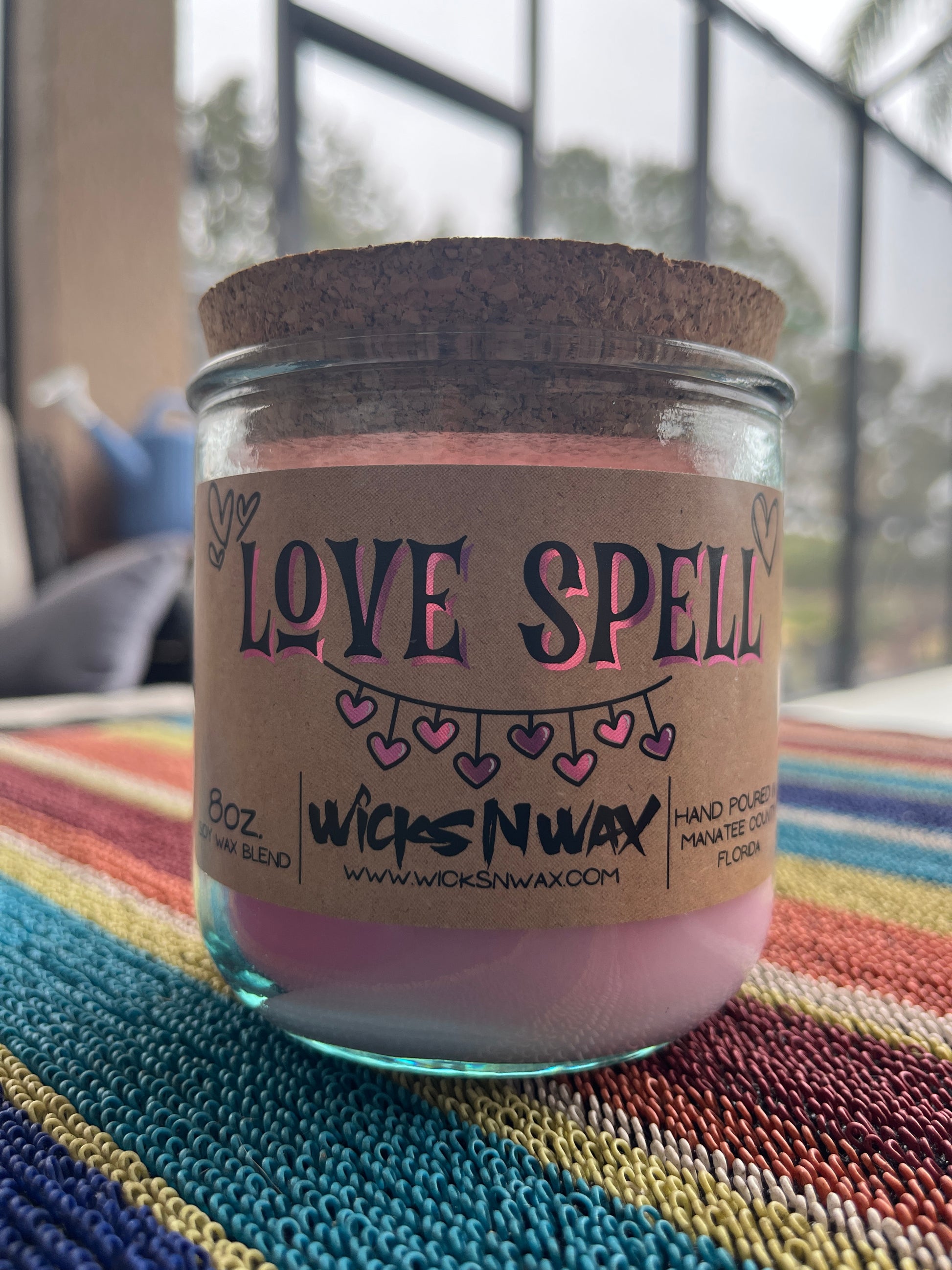 Recycled glass candle, purple jar with cork lid; 'LOVE SPELL' label on striped fabric
