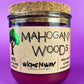 Recycled glass candle with cork lid and purple wax, front label showing Mahogany Woods.