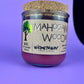 Recycled glass candle with cork lid and purple wax; side label and logo visible.