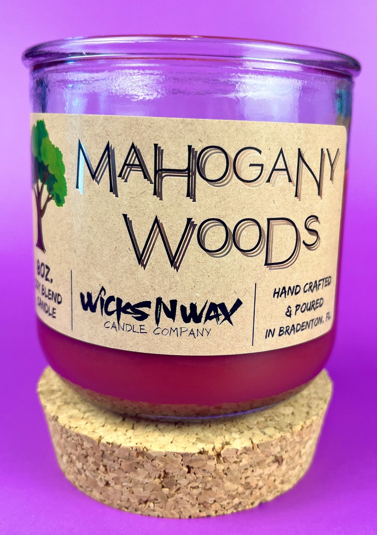 Recycled glass candle with cork lid, purple wax, label facing forward; cork base visible.
