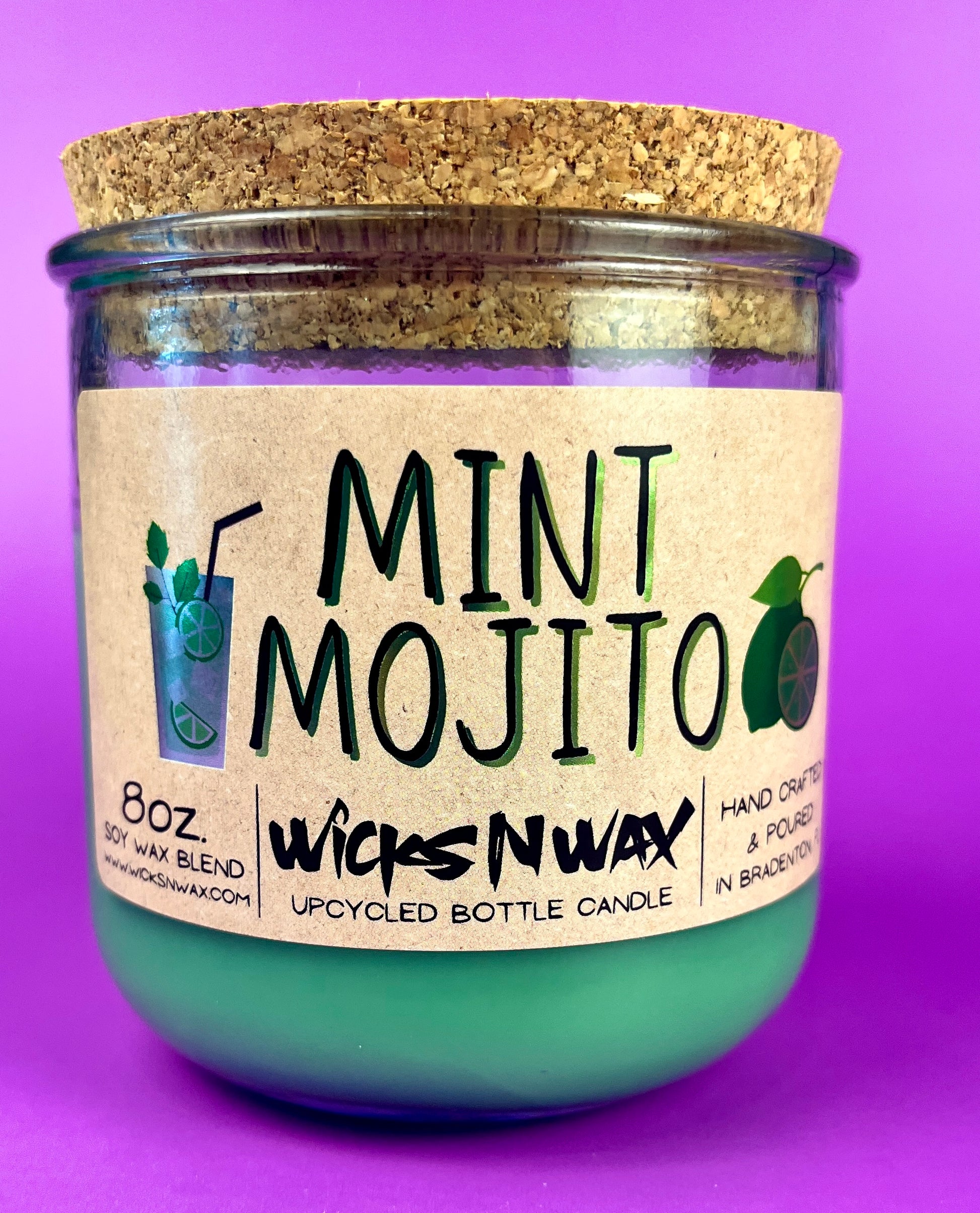 Recycled glass candle with mint-green wax, cork lid, side text and icons visible