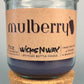 Mulberry WicksNWax upcycled bottle candle in clear glass jar with cork base, centered
