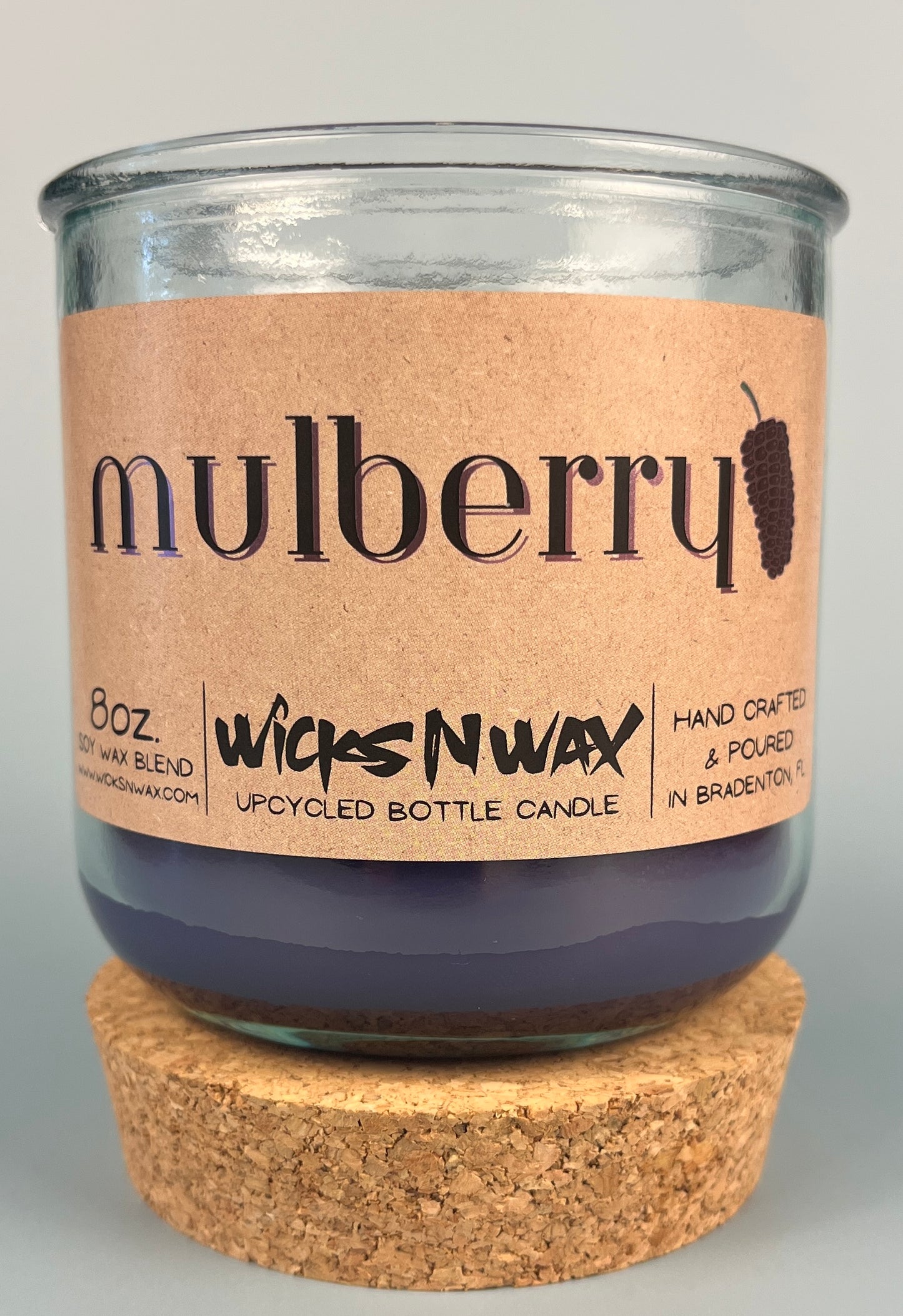 Mulberry WicksNWax upcycled bottle candle in clear glass jar with cork base, centered