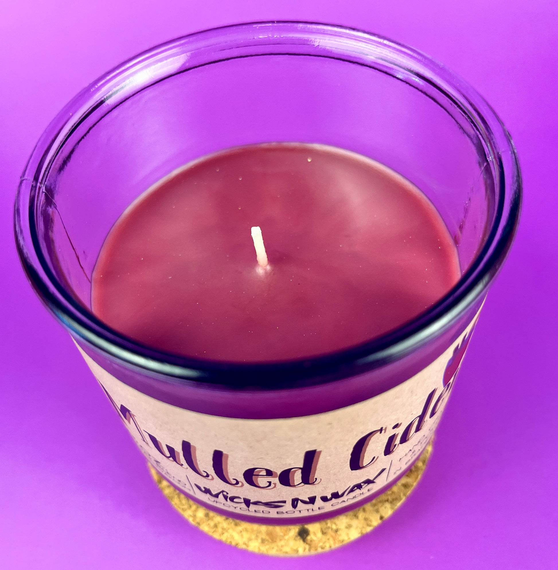 Mulled Cider recycled glass candle jar with visible wick and purple wax surface