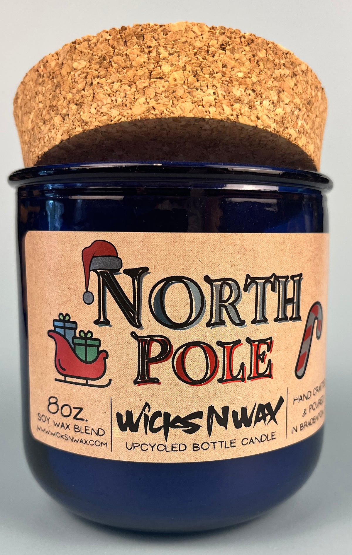 Blue glass candle on cork base with North Pole label, WicksNWax branding.