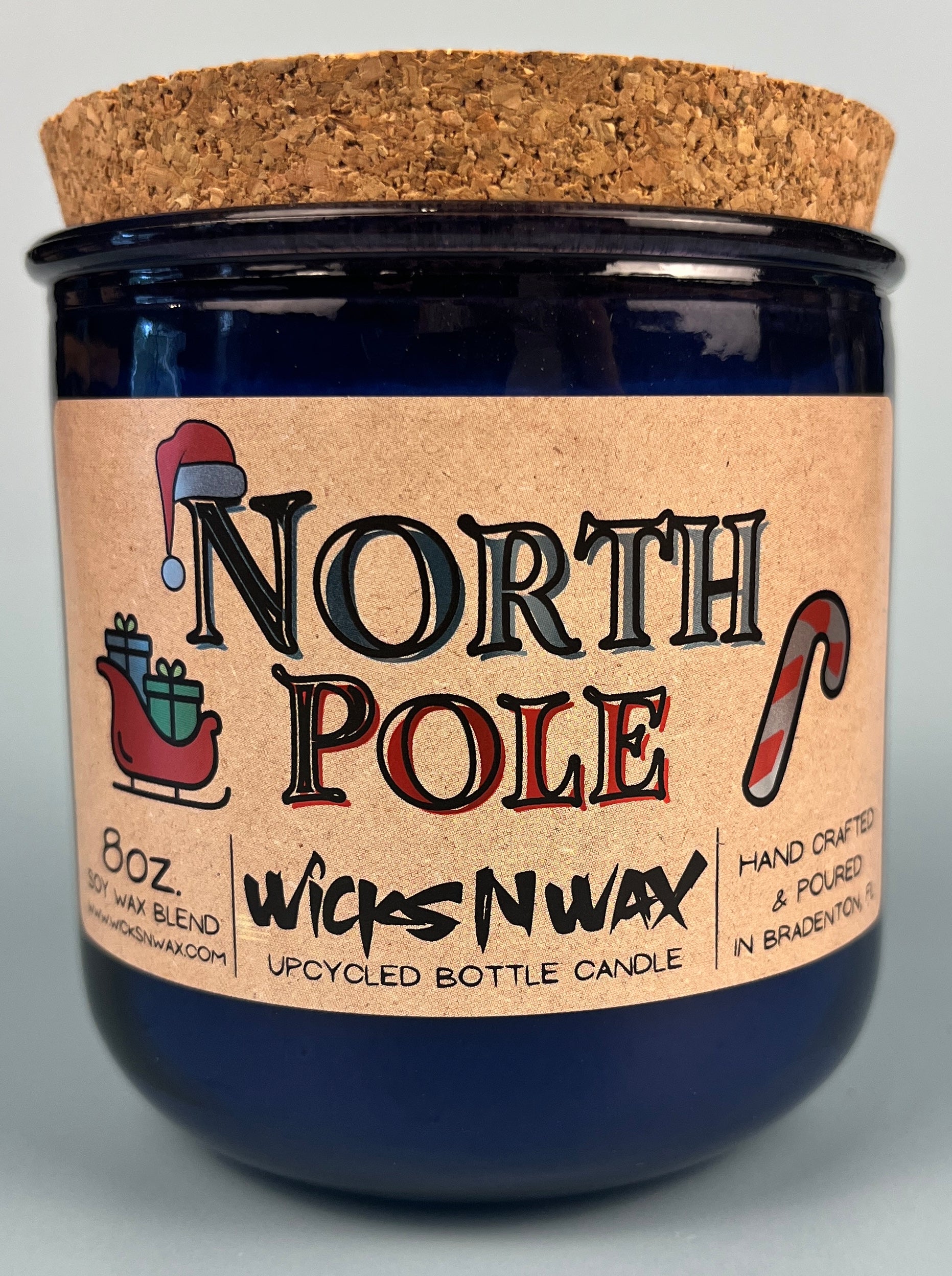 Blue glass candle jar with cork base and North Pole label, hand crafted text.
