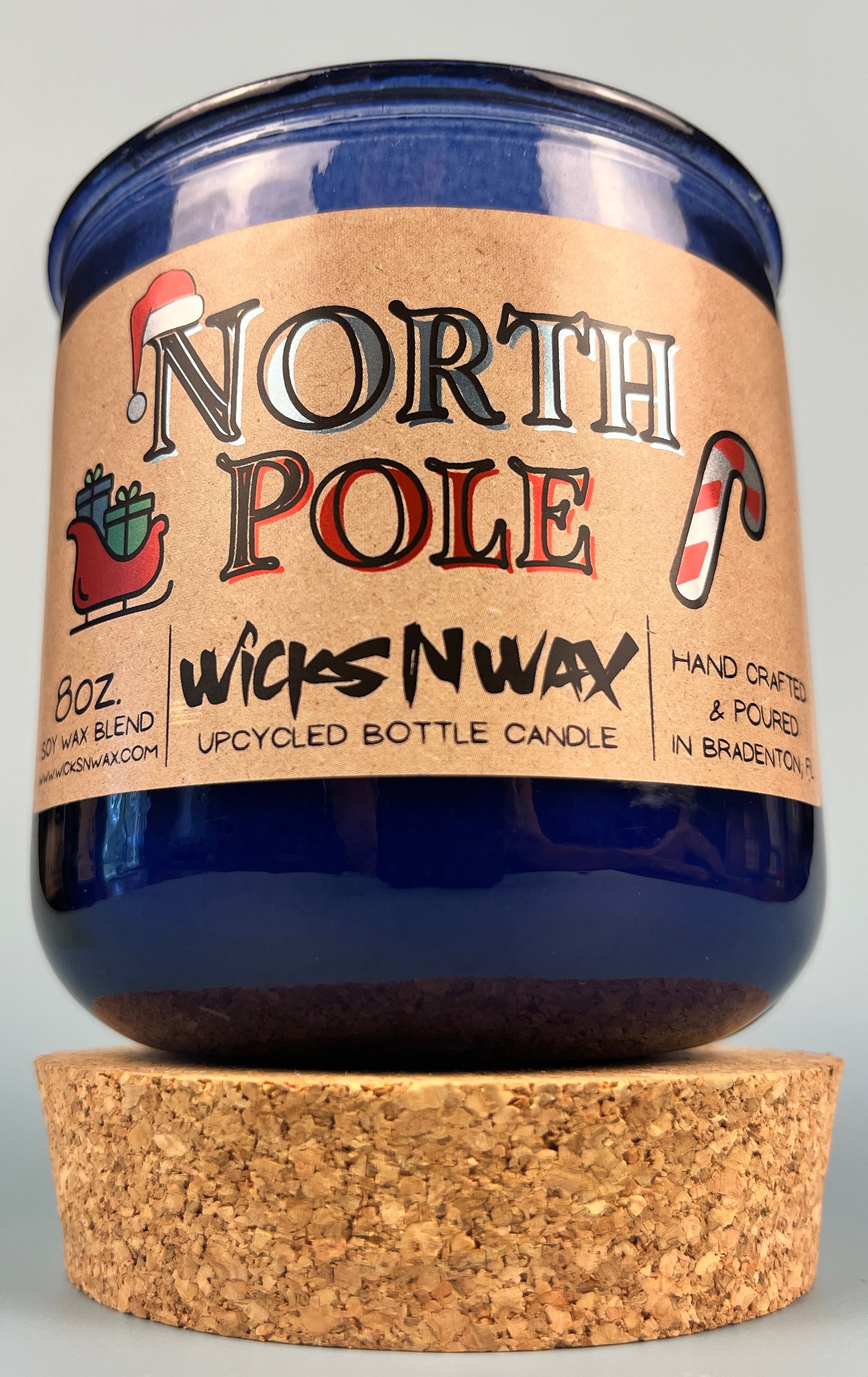 Blue glass candle jar on cork base with North Pole label and WicksNWax text.
