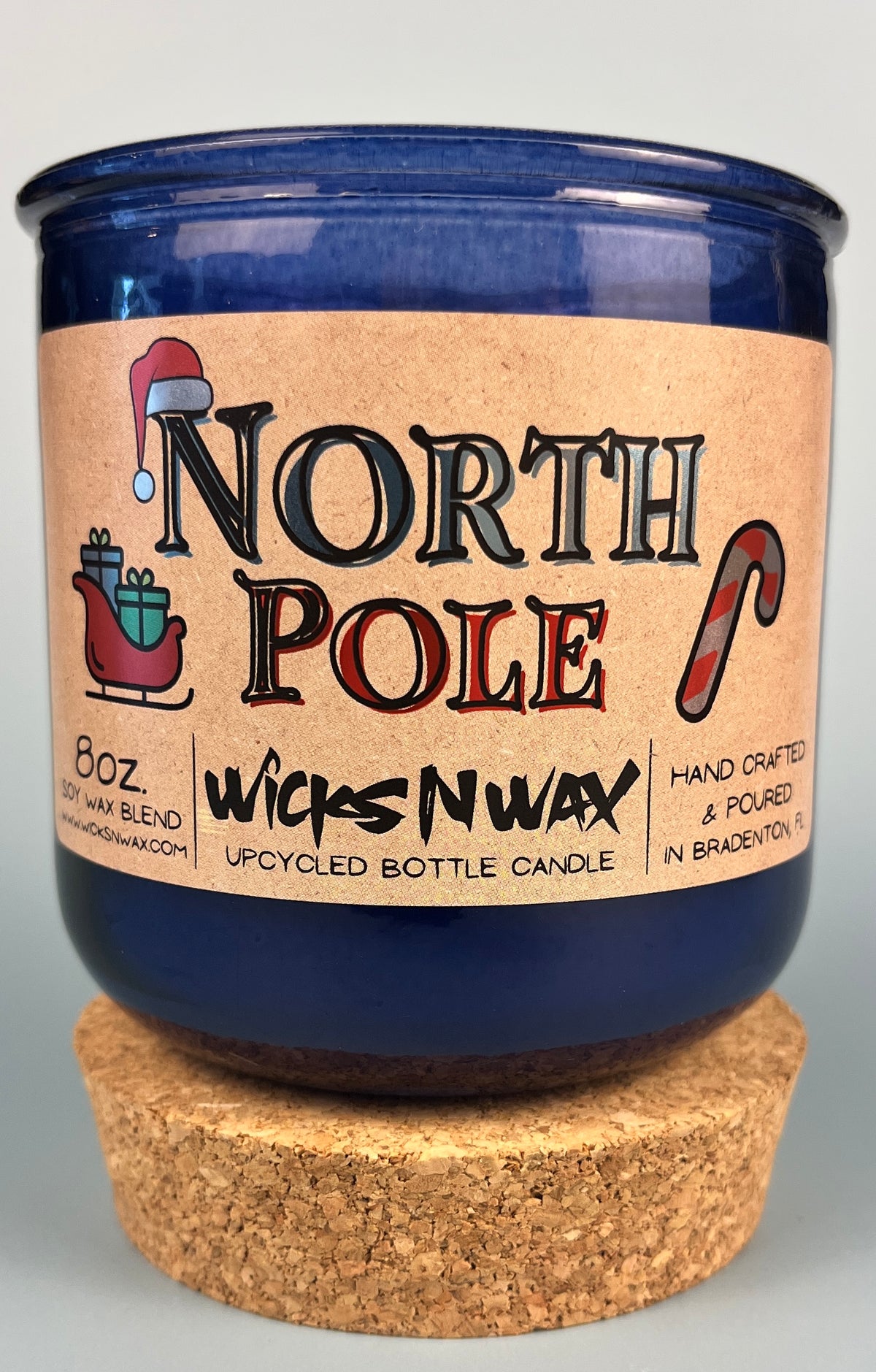 Recycled blue glass candle with cork base, North Pole label, WicksNWax branding.